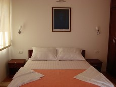 Кровать в спальне апарт-отеля "Барон"