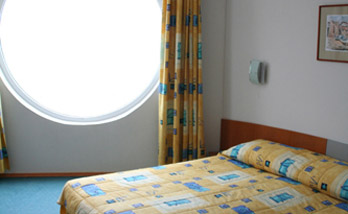 Широкая двуспальная кровать в номере отеля „Нептун Бич” 